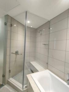 约翰内斯堡Spacious 2BR APT Near Sandton City -No Loadshedding的一间带玻璃淋浴和水槽的浴室