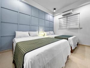 长滩岛Fully Furnished 1BR with Kitchen - 20 secs walk to the Beach - Newly Renovated的一间设有两张床的卧室,位于蓝色墙壁的房间