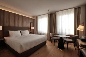 柏林AC Hotel by Marriott Berlin Humboldthain Park的酒店客房带一张床、一张桌子和椅子