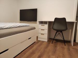 普福尔茨海姆Apartmenthaus Pforzheim的一间卧室配有一张桌子、一张床和一把椅子