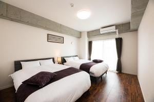 鹿儿岛STAYTUS - Vacation STAY 62201v的酒店客房设有两张床和窗户。