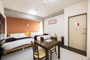 鹿儿岛STAYTUS - Vacation STAY 62199v的一间卧室配有两张床、一张桌子和一张桌子