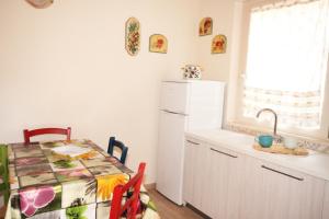 卡波利韦里Appartamento Il Mandorlo的厨房配有桌子和白色冰箱。