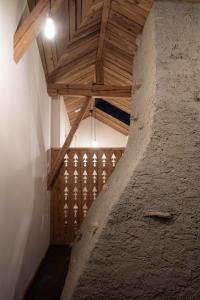 La SagneHôtel-Restaurant Le Cochon Rose的阁楼间设有木制天花板和楼梯。