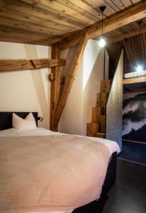 La SagneHôtel-Restaurant Le Cochon Rose的一间带一张床的卧室,位于带木制天花板的房间内