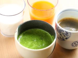 松江市Onyado Nono Matsue Natural Hot Spring的一碗绿色液体,紧贴两杯果汁