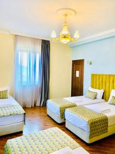 第比利斯Phazisi Hotel的酒店客房设有两张床和吊灯。