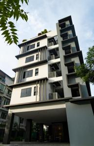 新加坡VicHaus Serviced Apartment的白色的建筑,旁边设有阳台