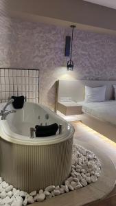 伊兹密尔Avwan Hotel Çiğli的带浴缸和床的大型浴室