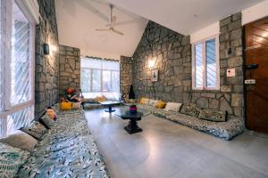 班加罗尔BYOC Hostels的一间设有石墙、沙发和桌子的房间