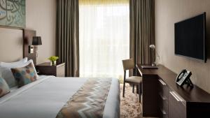 麦加麦加千禧M酒店的酒店客房配有一张床、一张书桌和一台电视。