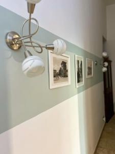 佛罗伦萨Leopoldini Appartamenti的走廊上设有天花板灯和墙上的照片