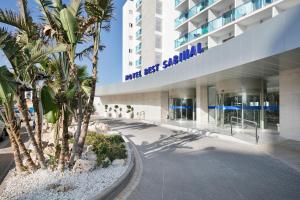 滨海罗克塔斯萨比纳尔最佳酒店的一座棕榈树环绕的大建筑