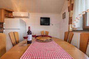 奥托亚克Vineyard Cottage Ucman - Happy Rentals的一张桌子,上面放着比萨饼和两杯葡萄酒