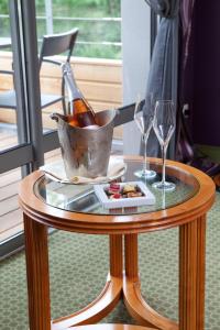 古德蒙特Logis La Source Bleue的一张桌子,上面放着一瓶香槟和两杯酒