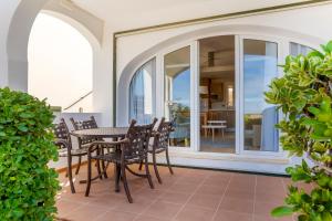 阿雷纳尔登卡斯特尔钻石度假村白沙海滩俱乐部酒店的阳台的天井配有桌椅