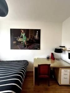 布洛涅-比扬古Appartement Confortable et Spacieux Boulogne-Billancourt的一间卧室配有一张床和一张桌子,墙上挂着一张照片