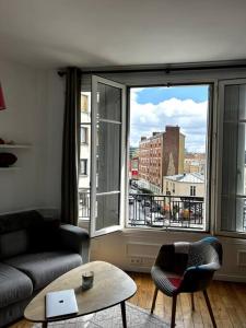 布洛涅-比扬古Appartement Confortable et Spacieux Boulogne-Billancourt的带沙发和大窗户的客厅