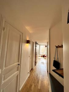 布洛涅-比扬古Appartement Confortable et Spacieux Boulogne-Billancourt的走廊上设有白色门,铺有木地板