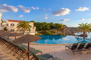 阿雷纳尔登卡斯特尔钻石度假村白沙海滩俱乐部酒店的一个带椅子和遮阳伞的游泳池的度假酒店