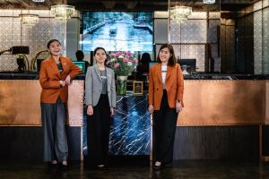 曼谷曼谷MUU酒店的站在柜台前的三名妇女
