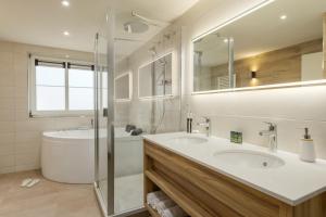 Gunderath艾弗尔茂矽纽伯格林中心公园酒店的浴室配有水槽、淋浴和浴缸。