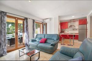 奇克拉纳－德拉弗龙特拉Carrajolilla Sancti petri的一间带蓝色沙发的客厅和一间厨房