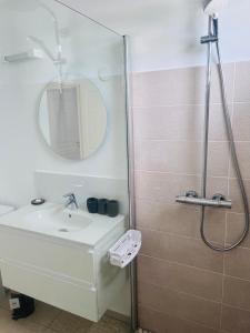 哥西尔Ruddy’s house的浴室配有盥洗盆和带镜子的淋浴