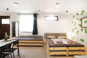 摩拉瓦河畔韦塞利Apartmán Wellness Veselí的一间卧室配有两张床和一张桌子及椅子