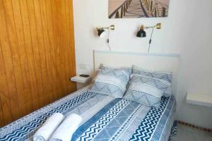 科尼尔-德拉弗龙特拉Apartamento Venus Conil的一张带蓝色和白色床单及枕头的床