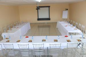 NqutuMeet Mekaar Resorts - Nquthu Hotel的一间白色床单房里的一排桌子