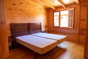 MinglanillaALBERGUE CONTRERAS的小木屋内一间卧室,配有一张床
