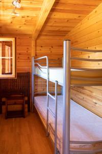 MinglanillaALBERGUE CONTRERAS的小屋设有两张双层床,配有木墙