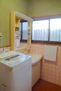 四万十市四万十川傍にある日本家屋まるごと「貸切宿　ほとり」的一间带洗衣机和水槽的浴室