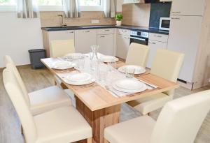 毛特恩多夫Appartement Mauterndorf的厨房配有木桌和白色椅子