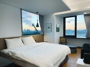 台北小隐居 Hermit Dorm的卧室设有一张白色大床和两个窗户。
