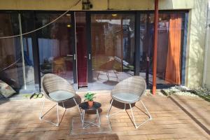 安特卫普Lux & Cozy Apt + Garden +Jaccuzi的天井上配有两把椅子和一张桌子及植物