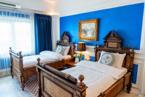 Ban Si ThanThe White Rabbit Hostel的卧室设有两张床铺和蓝色的墙壁