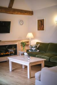 米德赫斯特Cowdray Holiday Cottages的带沙发和咖啡桌的客厅