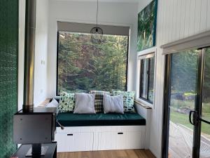 AlonnahLittle Pardalote Tiny Home Bruny Island的一个小房子里的一个靠窗座位,有绿色长凳