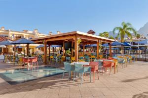阿德耶皇家日落海滩俱乐部钻石度假公寓的一个带桌椅和遮阳伞的庭院