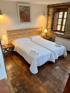 ArmañoCasa Rural Basiver - Habitación Pico San Carlos的卧室内的一张大白色床,配有两盏灯