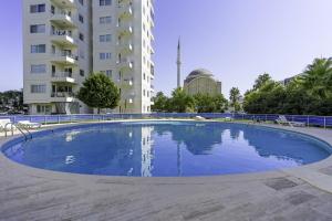 安塔利亚Flat w Pool Garden 3 min to Beach in Antalya的大楼前的大型蓝色游泳池