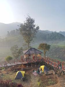 希维德Gunung bangku ciwidey rancabali camp的山丘上一组帐篷,有一座桥