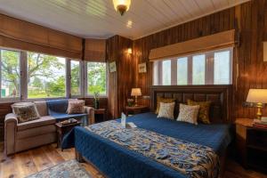 帕哈尔加姆LohonoStays Villa Hill Retreat的一间卧室配有一张床、一把椅子和窗户。