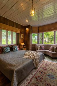帕哈尔加姆LohonoStays Villa Hill Retreat的一间卧室配有一张床、一张沙发和窗户。
