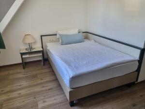 伊塞尔恩哈根伊瑟哈根健身公园酒店的一间卧室配有一张床和一个带灯的床头柜
