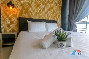 迪沙鲁Desaru Luxury Homestay - near WaterPark, RAPID, Beach的一张带白色毯子的床和一株植物