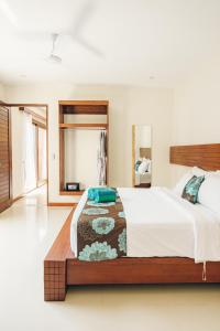 吉利特拉旺安Taj Maza Sunset Villas的一间卧室设有一张大床和一个大镜子