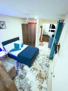 班布里Semo's apartment的一间卧室配有一张蓝色的床,铺有一个碎地板。